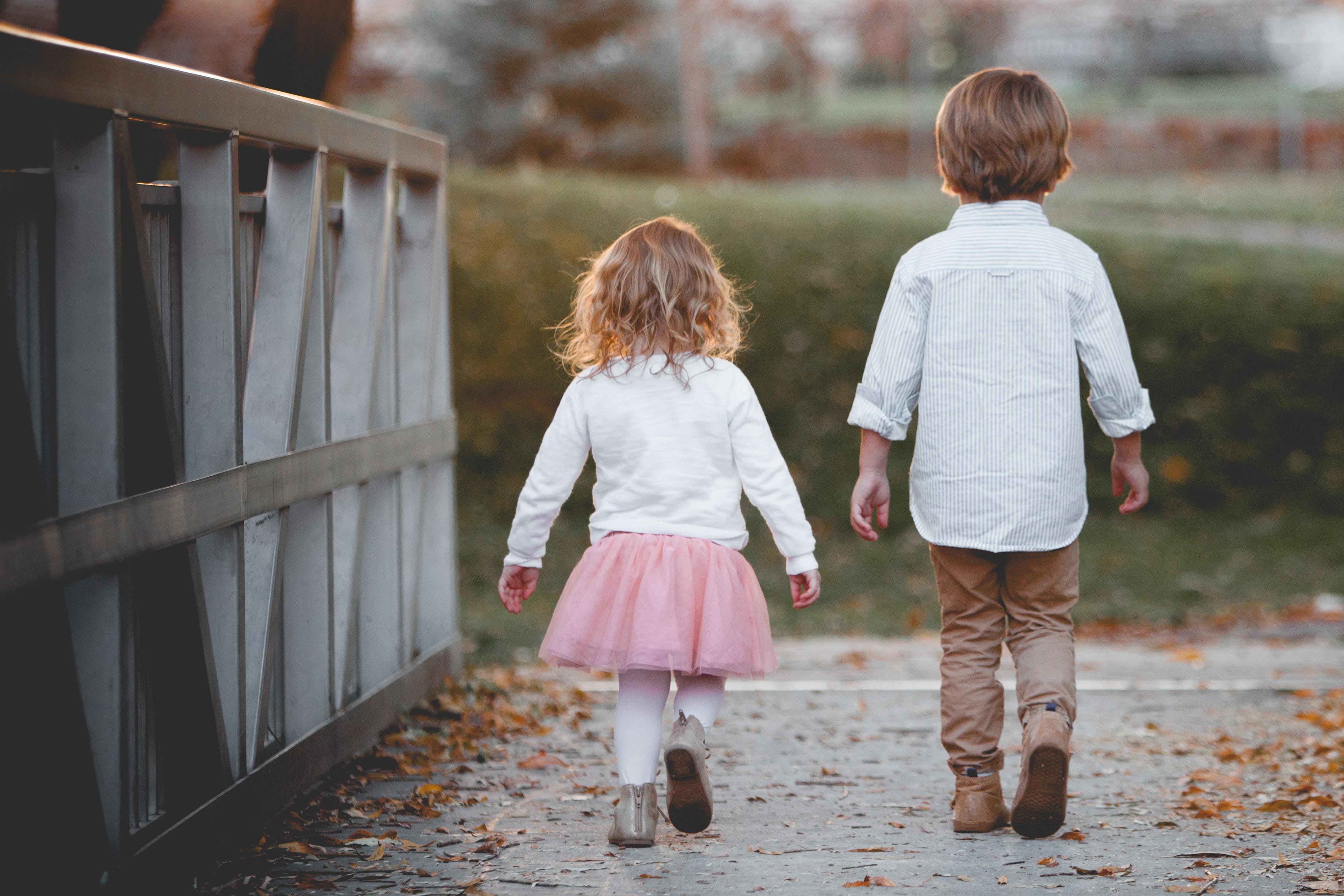 niña y niño caminando juntos.